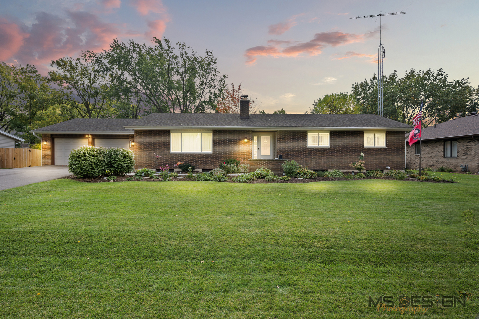 a front view of a house with a garden and plants