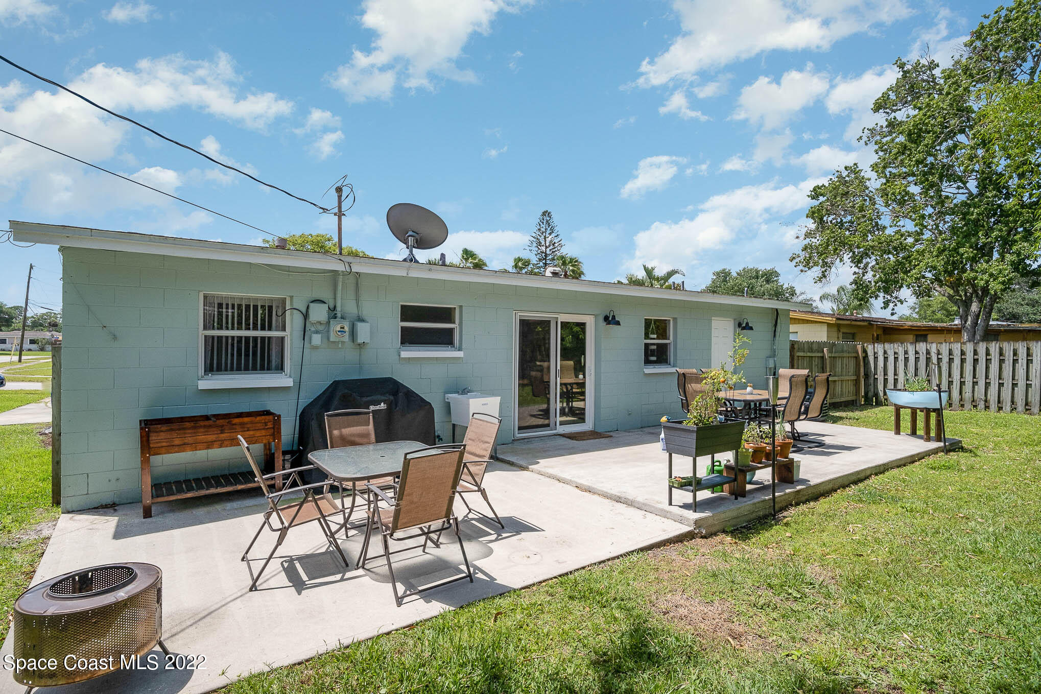 1080 Madrid Road Rockledge, FL 32955 - Photo 17 of 21 a view of a patio with table and chairs potted plants and a large tree