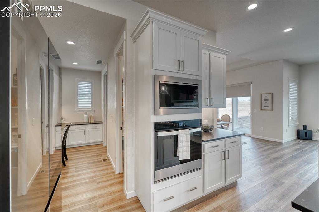 10059 Owl Perch Loop Colorado Springs, CO 80908 - Photo 16 of 50 Kitchen featuring white cabinetry, stainless steel appliances, light wood-type flooring, and recessed lighting