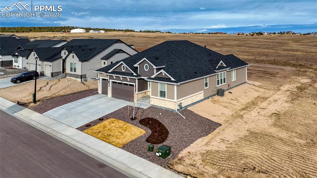 10059 Owl Perch Loop Colorado Springs, CO 80908 - Photo 4 of 50 View of front of house with concrete driveway, stone siding, and an attached garage