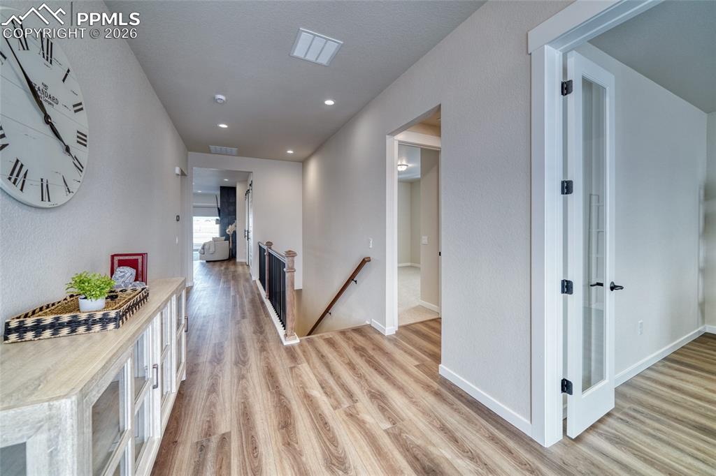 10059 Owl Perch Loop Colorado Springs, CO 80908 - Photo 10 of 50 Corridor featuring an upstairs landing, light wood finished floors, and recessed lighting