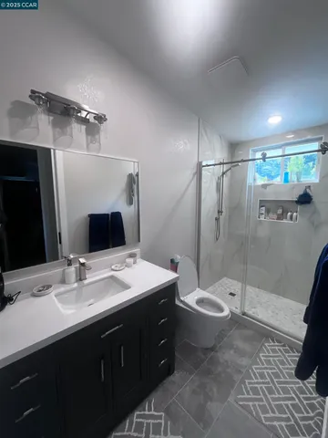 a bathroom with a double vanity sink toilet and mirror