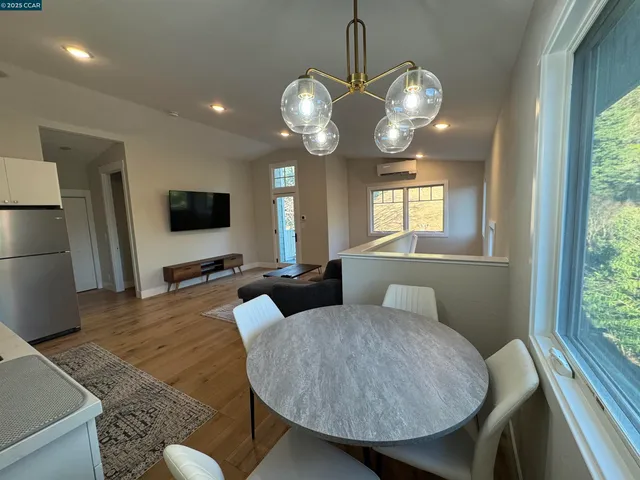 a living room with furniture a large window and a flat screen tv