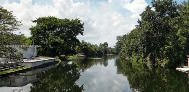 a view of river covered by trees and buildings