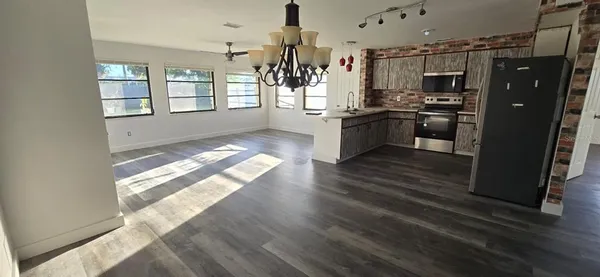 a kitchen with stainless steel appliances kitchen island wooden floors granite counter tops and window