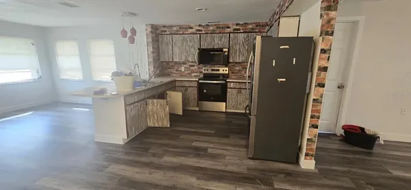 a kitchen with granite countertop a refrigerator and a stove top oven