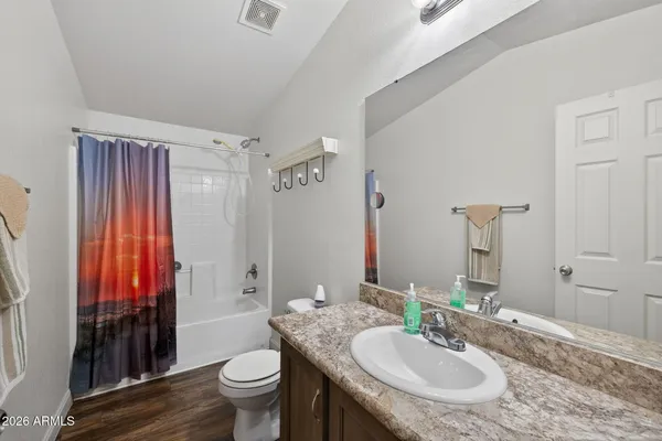 a bathroom with a granite countertop sink toilet and shower