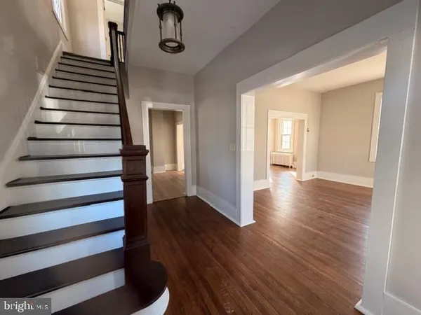 a view of a hallway with wooden floor and staircase