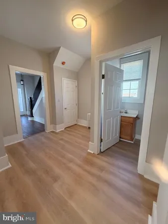 a view of a livingroom with wooden floor and a hallway