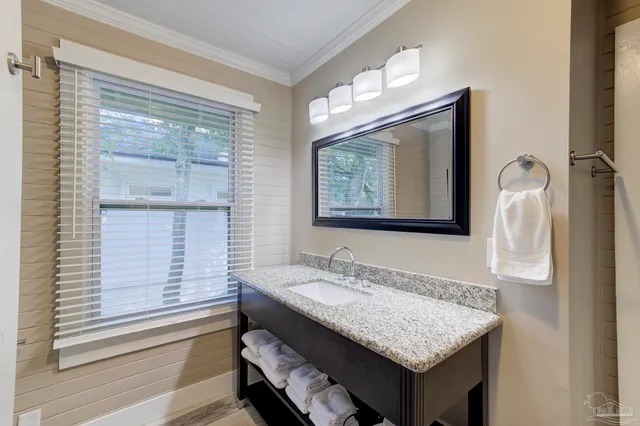 a bathroom with a granite countertop sink a mirror and a shower