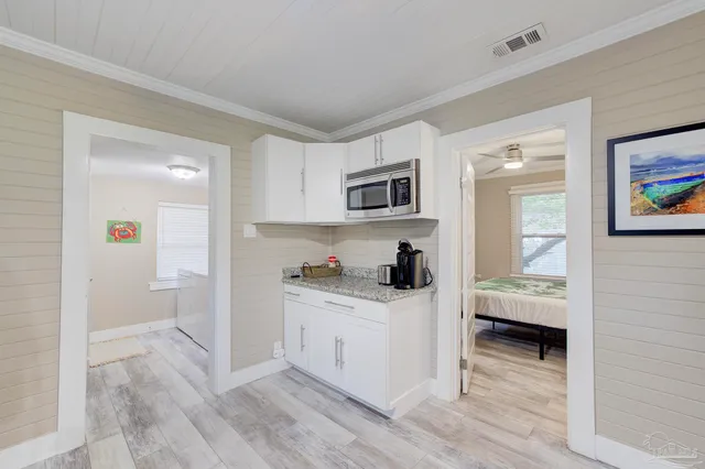 a kitchen with microwave a stove and cabinets