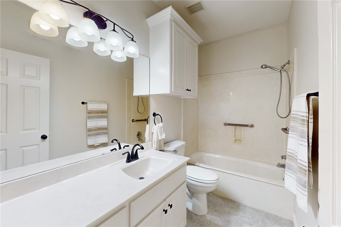 2619 Trophy Drive Bryan, TX 77802 - Photo 25 of 28 a bathroom with a sink a toilet and a large mirror