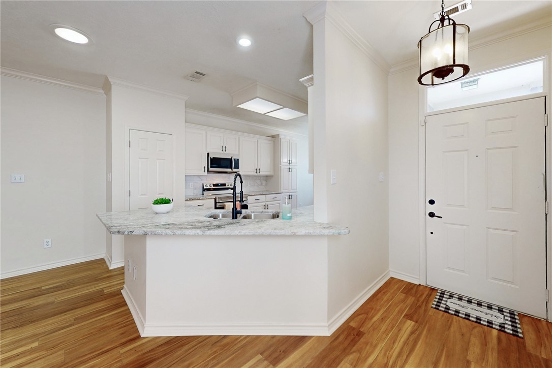 2619 Trophy Drive Bryan, TX 77802 - Photo 5 of 28 a view of a kitchen with kitchen island a sink wooden floor and black appliances