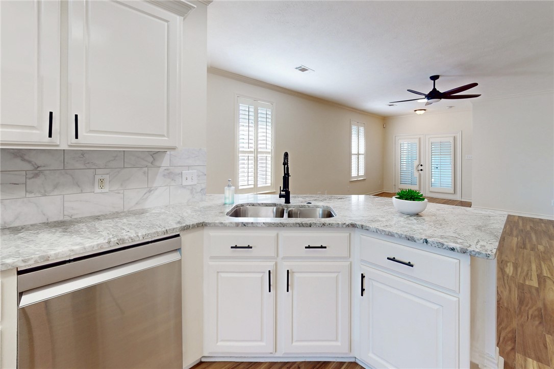 2619 Trophy Drive Bryan, TX 77802 - Photo 6 of 28 a kitchen with granite countertop a sink and white cabinets