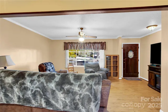 a living room with furniture a chandelier and a flat screen tv