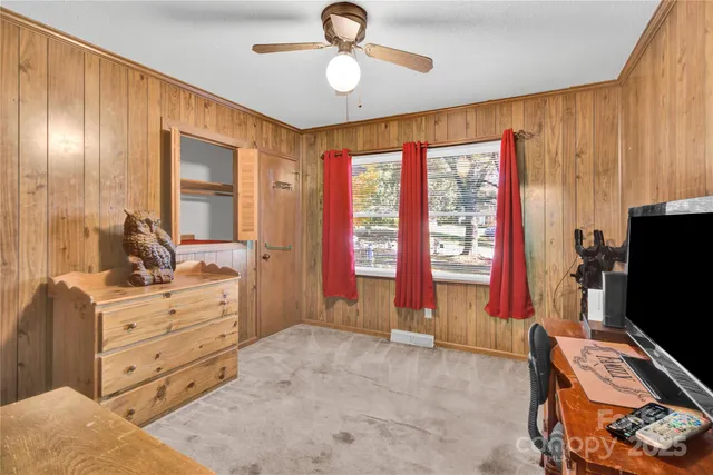 a bedroom with a bed and large windows