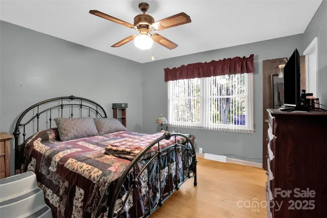 a bedroom with a bed a window and a chandelier