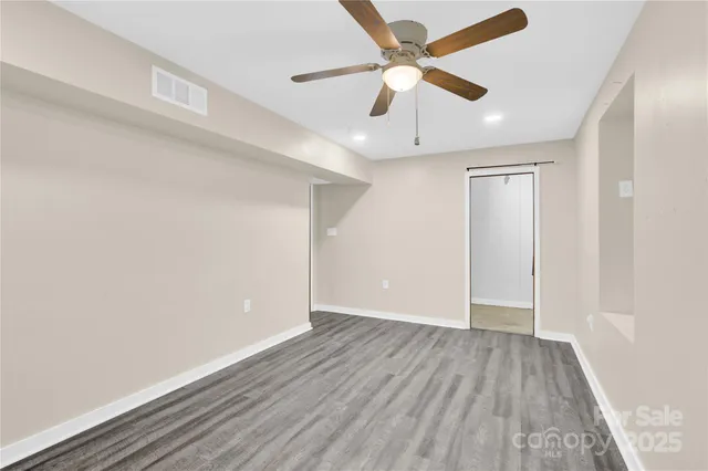 a view of an empty room with wooden floor
