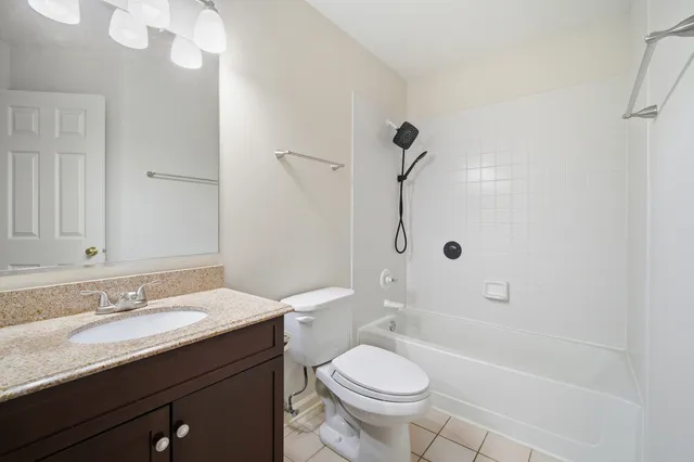 a bathroom with a granite countertop sink a toilet and shower