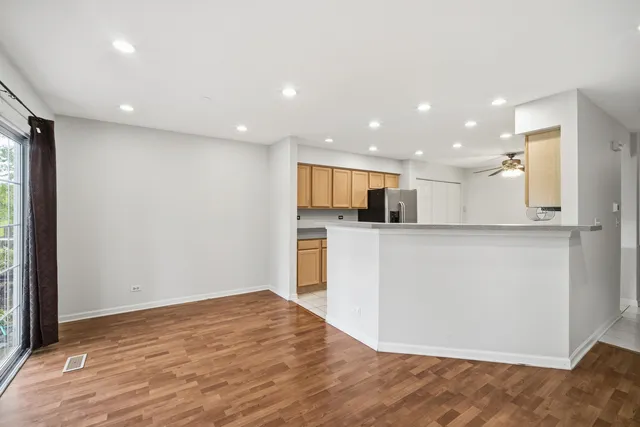 a view of kitchen with kitchen island granite countertop refrigerator and microwave