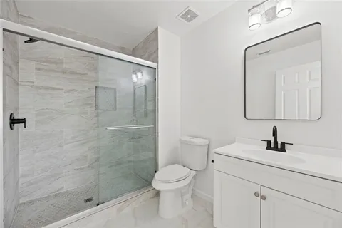 a bathroom with a toilet a sink a mirror and vanity