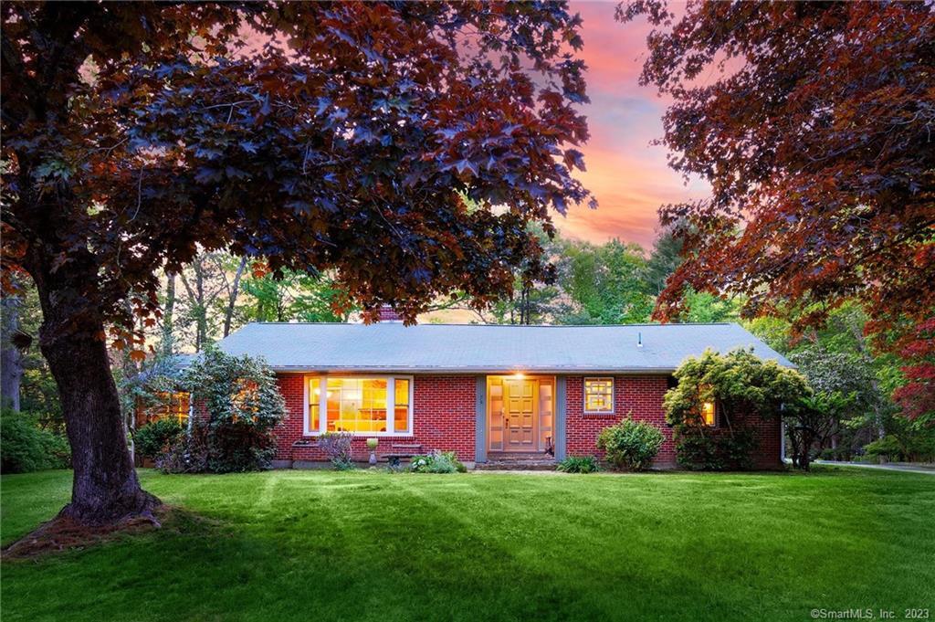 a view of a house with a big yard and a large tree