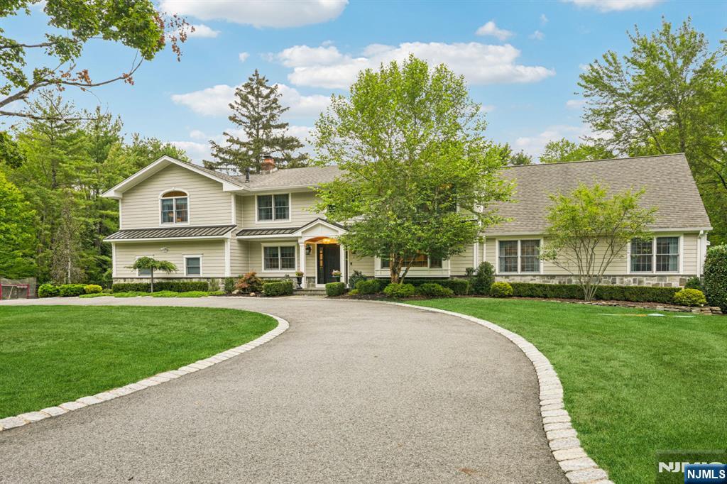 1015 High Mountain Road Franklin Lakes, NJ 07417 - Photo 2 of 48 a front view of a house with a garden and trees
