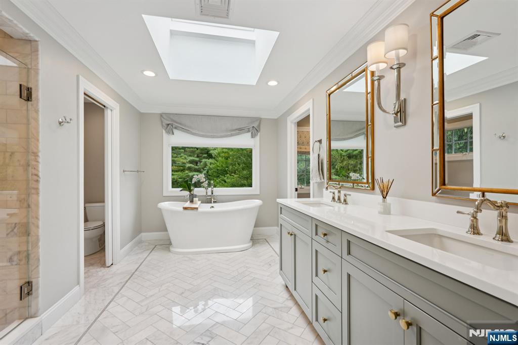 1015 High Mountain Road Franklin Lakes, NJ 07417 - Photo 34 of 48 a large bathroom with a granite countertop sink a large mirror a bathtub and window