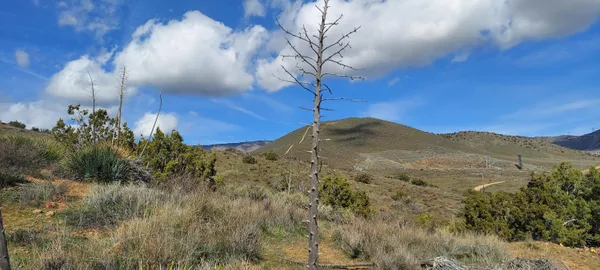 a view of a house with a mountain and a yard