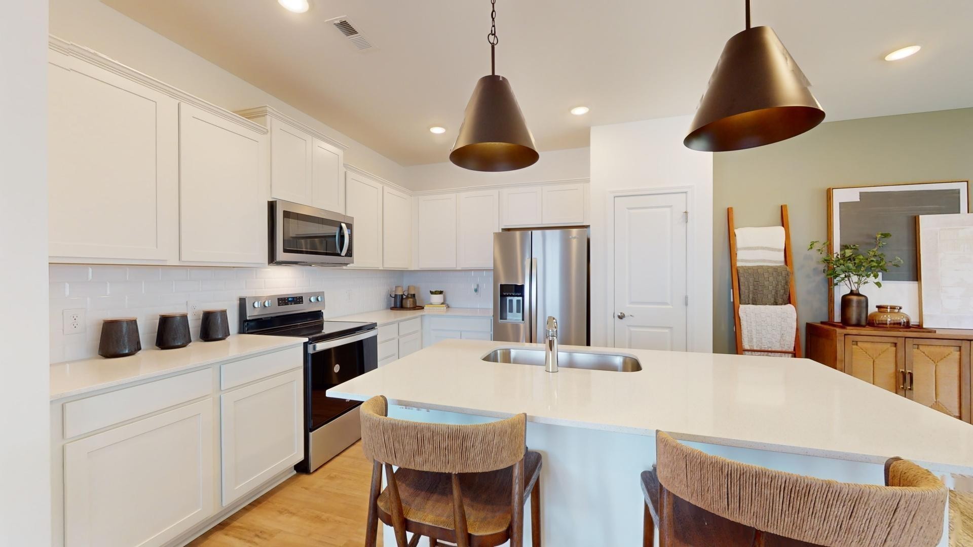 7110 Mapleside Lane Fairview, TN 37062 - Photo 22 of 49 a kitchen with stainless steel appliances a stove a sink a microwave a refrigerator a stove a dining table and chairs