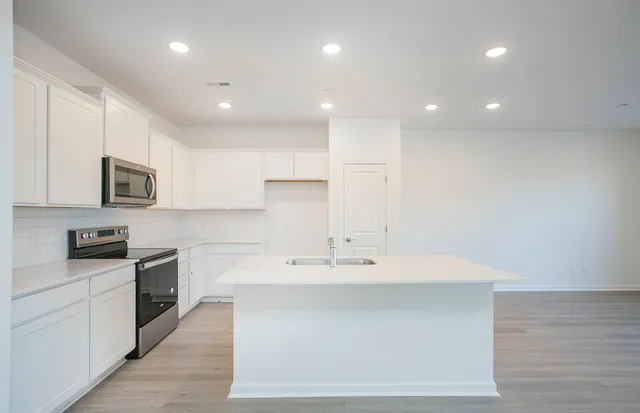 a kitchen with a sink a counter top space stainless steel appliances and cabinets