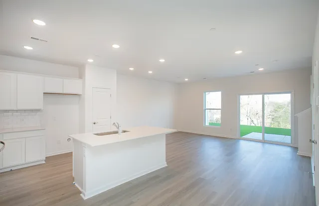 a view of kitchen with stainless steel appliances refrigerator stove and wooden floor
