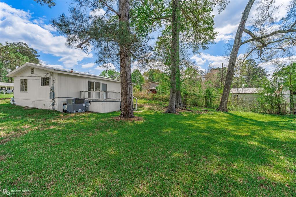 224 Prysock Road Doyline, LA 71023 - Photo 21 of 34 a view of a backyard with plants and a large tree