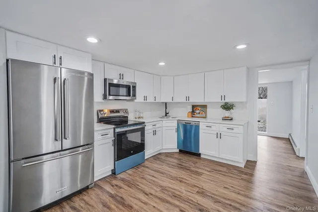 a kitchen with a refrigerator stove and wooden floors