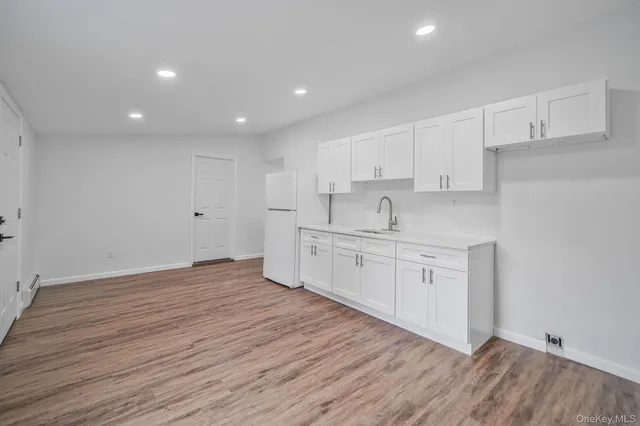 a kitchen with cabinets wooden floor and a sink