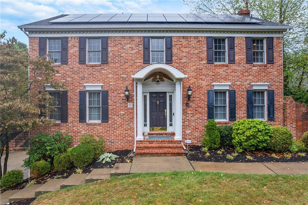 front view of a brick house with a yard