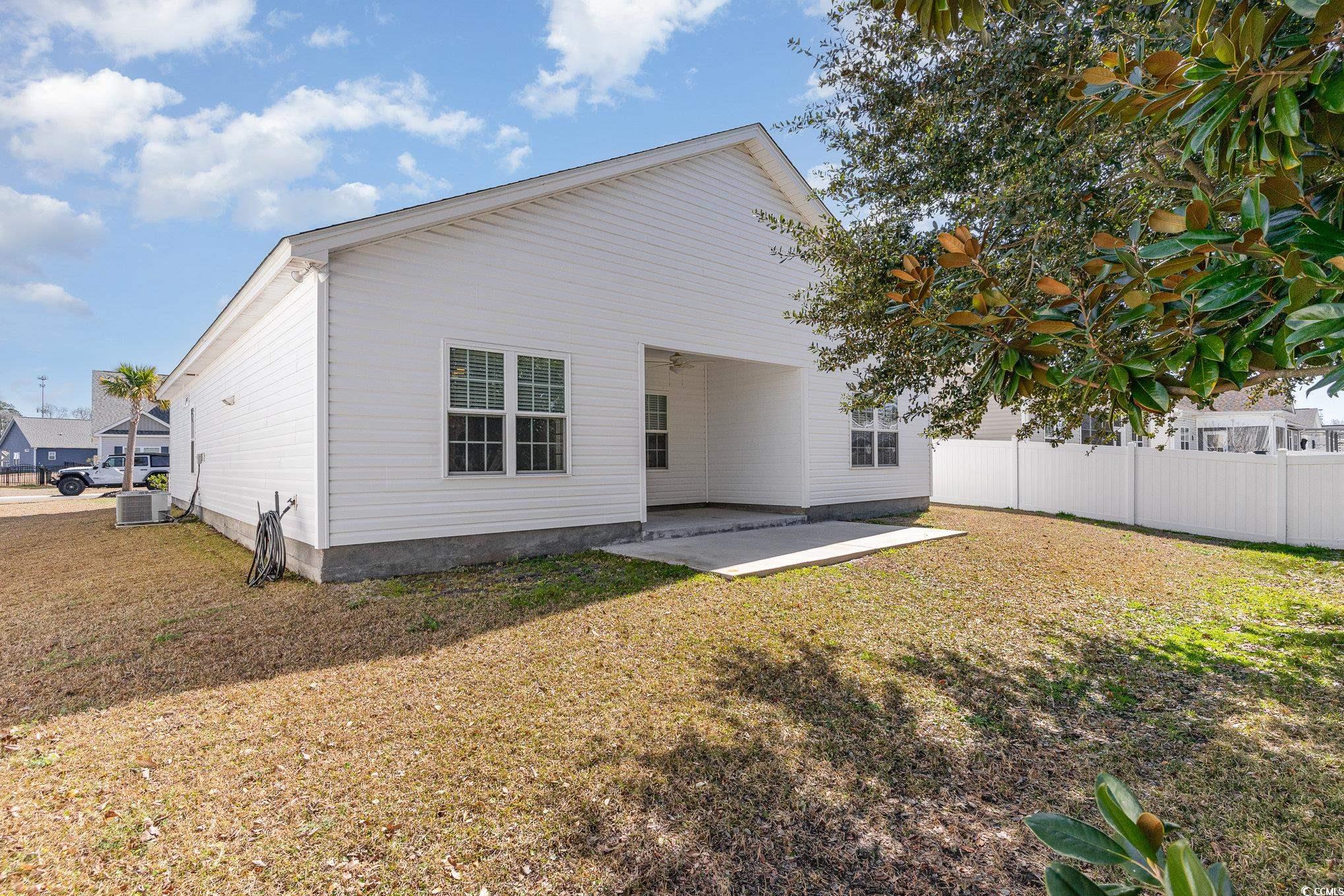 577 Rycola Circle Surfside Beach, SC 29575 - Photo 23 of 28 Rear view of property with central AC, a lawn, a p