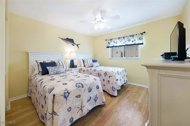 a bedroom with a large bed and a flat tv screen on dresser