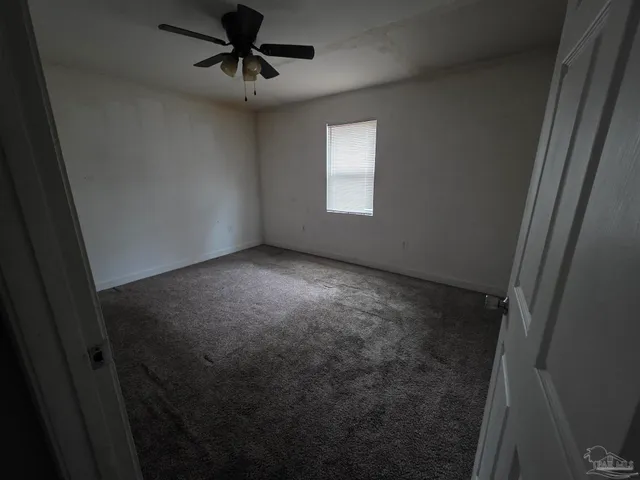 a view of a livingroom with a ceiling fan and window