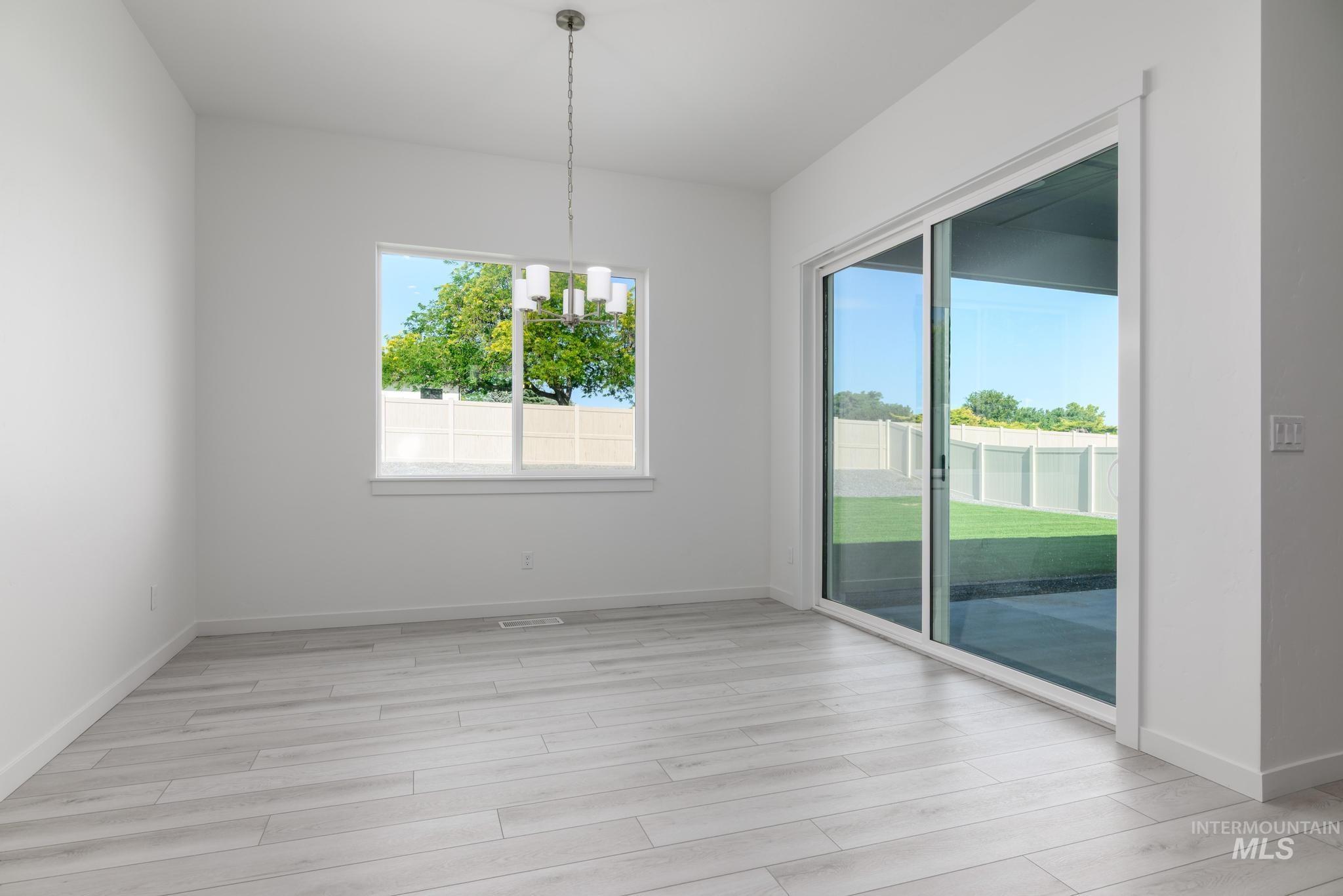 5416 Sparky Avenue Caldwell, ID 83607 - Photo 16 of 42 Unfurnished dining area featuring a chandelier and light wood-style floors