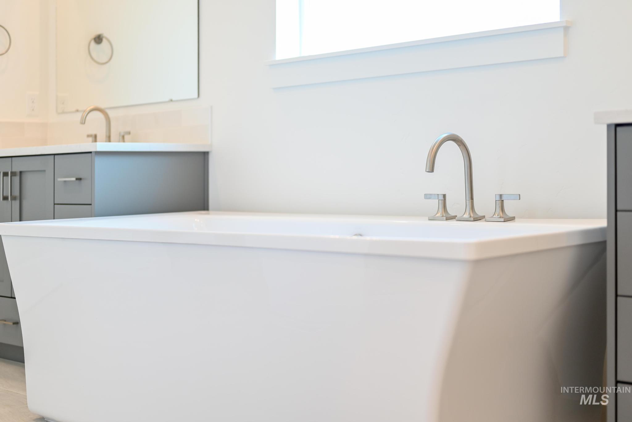 5416 Sparky Avenue Caldwell, ID 83607 - Photo 21 of 42 Full bathroom with double vanity and a freestanding tub