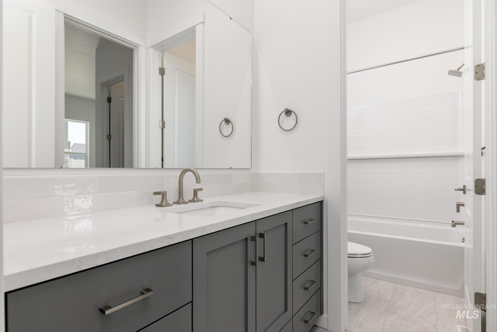 5416 Sparky Avenue Caldwell, ID 83607 - Photo 25 of 42 Bathroom featuring vanity, bathtub / shower combination, and light tile patterned floors