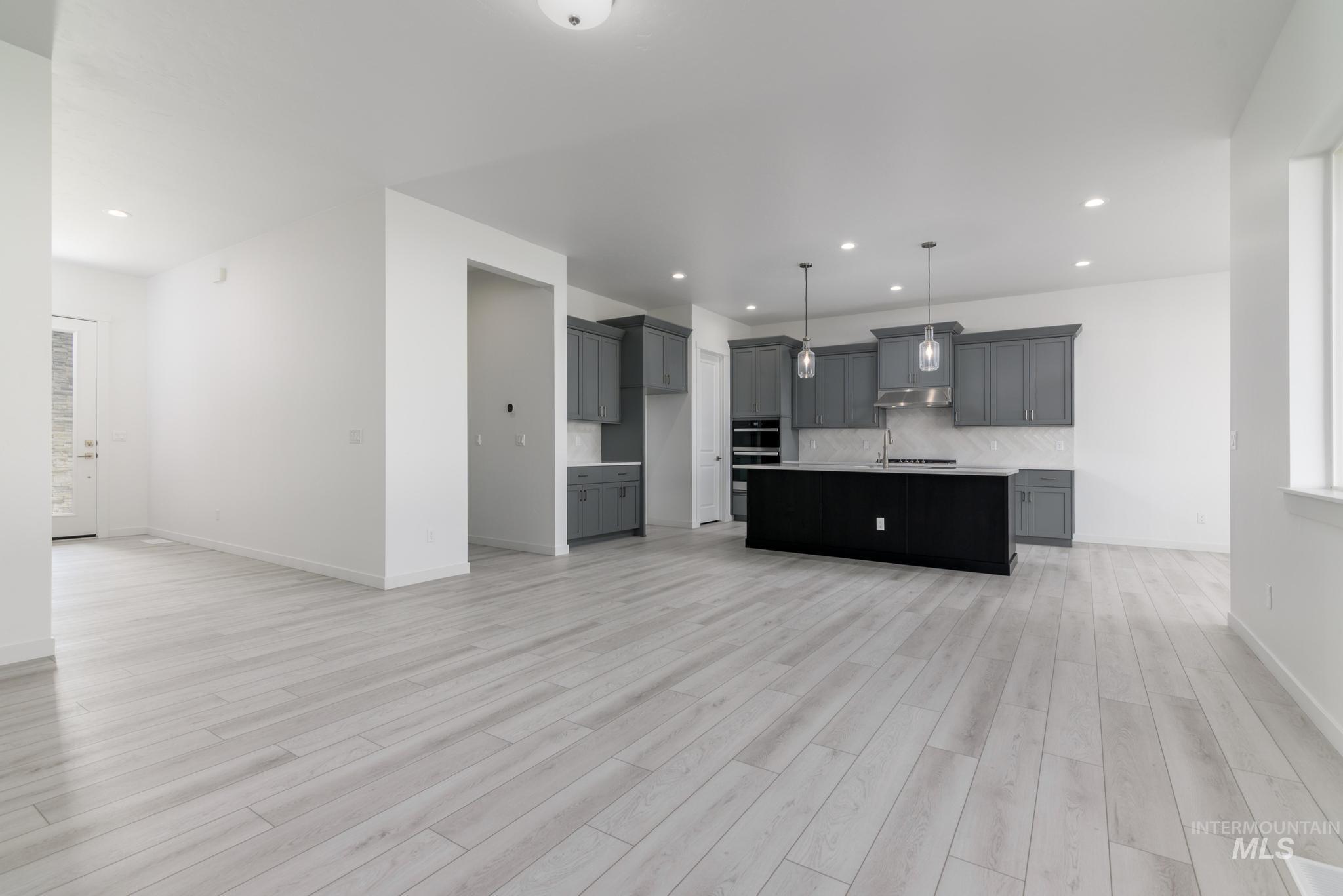 5416 Sparky Avenue Caldwell, ID 83607 - Photo 42 of 42 Kitchen with open floor plan, decorative backsplash, decorative light fixtures, an island with sink, and recessed lighting