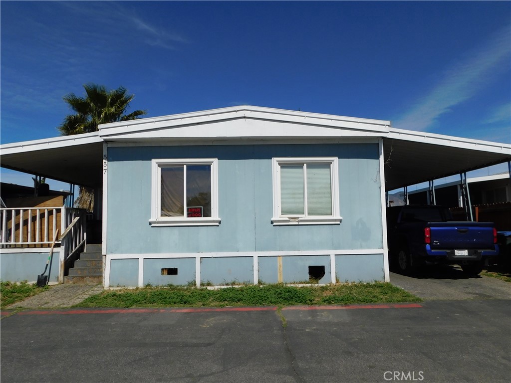 1097 North State Street, Unit 557 Hemet, CA 92543 - Photo 2 of 18 a front view of a house with a yard