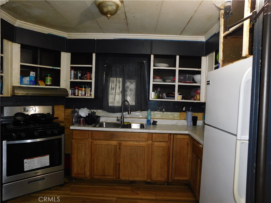 1097 North State Street, Unit 557 Hemet, CA 92543 - Photo 7 of 18 a kitchen with a sink and a refrigerator
