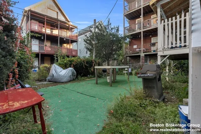 a backyard of a house with table and chairs
