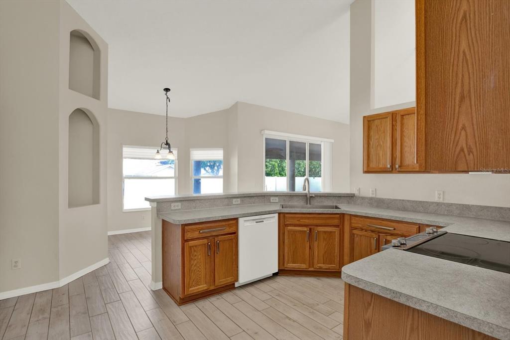 4400 Dior Road Spring Hill, FL 34609 - Photo 17 of 37 a kitchen with a sink cabinets wooden floor and stainless steel appliances