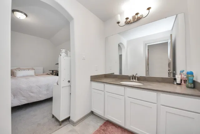 a en suite bathroom with a double vanity sink and a mirror