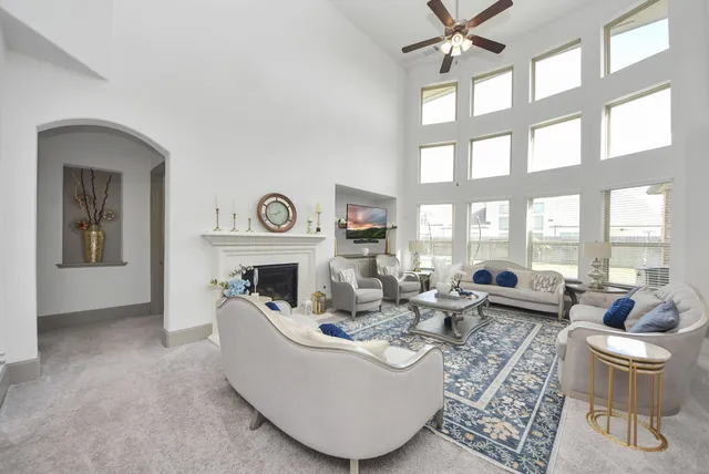 a living room with furniture a fireplace and a large window with garden view