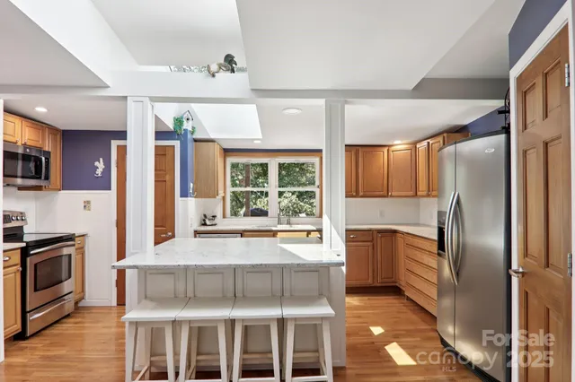 a kitchen with kitchen island granite countertop a stove oven and sink